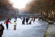 900009 Afbeelding van schaatsers op de bevroren Stadsbuitengracht te Utrecht, met op de achtergrond de Bartholomeïbrug.